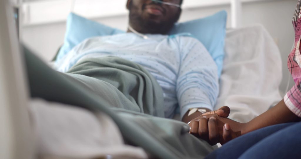 Knights Legal Services - A man laying in a hospital bed next to a woman.