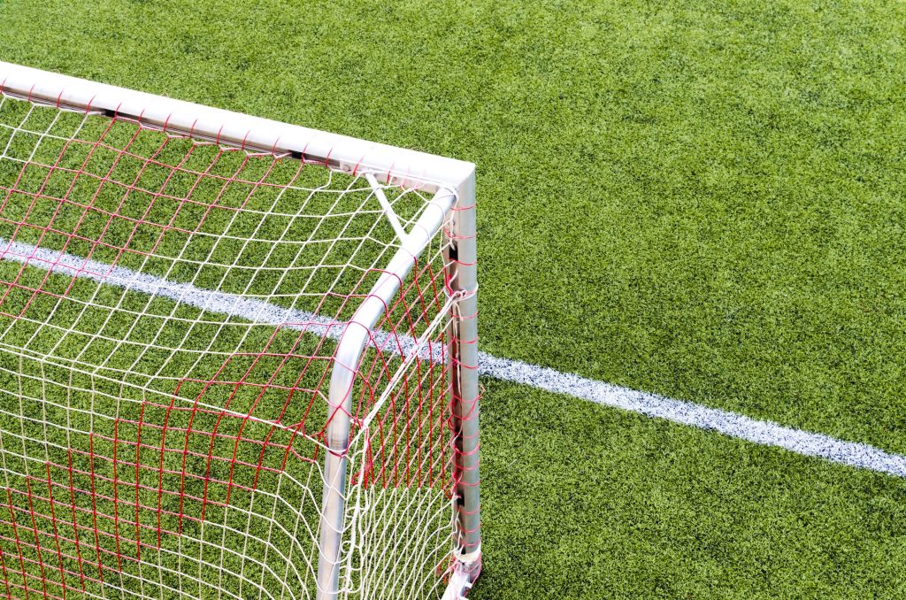 Knights Legal Services - A soccer goal on a green field with a white line.